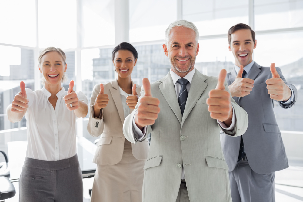 Business people giving thumbs up in the meeting room