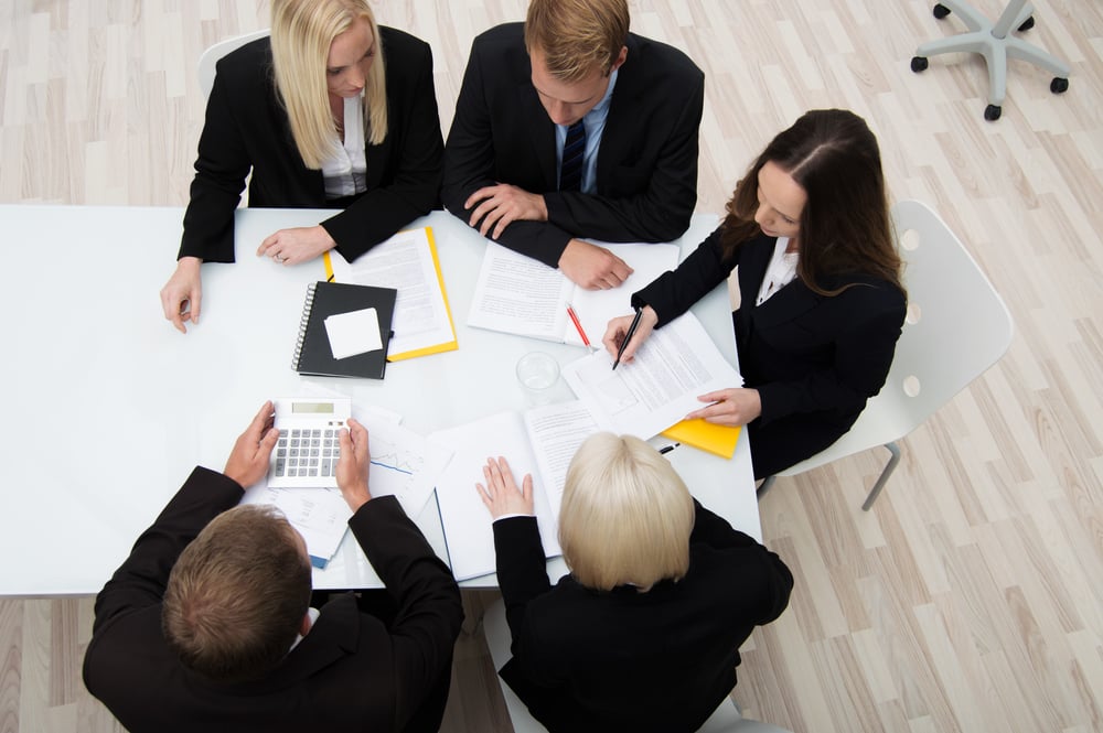 High angle view of a group of young successful businesspeople in a meeting analyzing and planning a new strategy